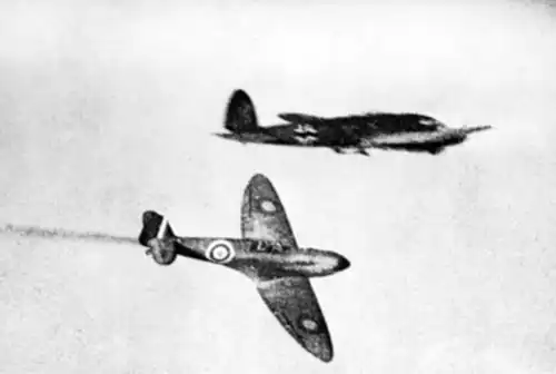 British Supermarine Spitfire fighter aircraft (bottom) flying past a German Heinkel He 111 bomber aircraft (top) during the Battle of Britain in 1940
