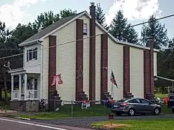 A semi-detached house separated from its attached neighbor with five buttresses being used to support the shared wall after the attached house was removed