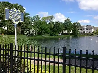 Sign referring to Suffolk County's 1683 founding located in Peterkin Park on Oak Street in Amityville.