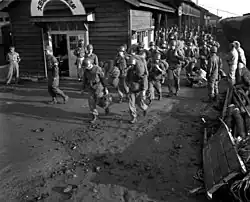 Soldiers carrying their bags off of a train in Daejeon train station, South Korea