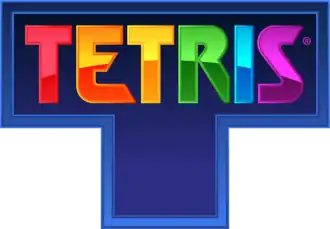 The word "Tetris", each letter a different color, engraved on a blue, T-shaped tetromino.