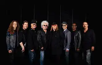 From left to right: Dennis Atlas, Warren Ham, David Paich, Steve Lukather, Joseph Williams, John Pierce, Greg Phillinganes, and Shannon Forrest