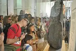 A crowd of visitors examining the Rosetta Stone at the British Museum in 2014, now behind glass
