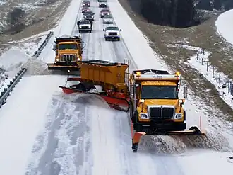 Trucks plowing snow on a highway in Missouri