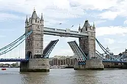 A tall drawbridge, open, over a river