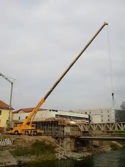 Truck mounted crane building a bridge