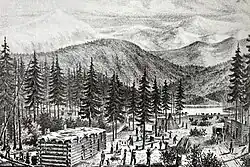 Three log cabins with flat roofs set in the midst of tall trees, with mountains in the background. People, livestock, and covered wagons are engaged in various activities in a clearing in the middle of the cabins.