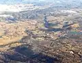 Aerial photo of Tuggeranong Town Centre, with Murrumbidgee River behind, Bullen Range is behind and Tidbinbilla Tracking Station is visible too.