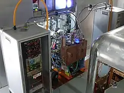 Two ion sources at the center with two high-voltage electronics cabinets next to them[40]