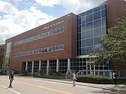 A brick and glass clad building is seen alongside a street.