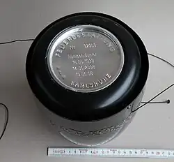 A sealed cinerary urn, showing the ash capsule containing the remains of the dead, along with the name and dates