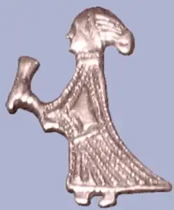 A silver figure of a woman holding a drinking horn found in Birka, Björkö, Uppland, Sweden.