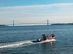 United States Coast Guard on patrol in Upper New York Bay. The Verrazzano–Narrows Bridge across the Narrows is visible in the background.