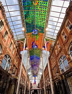 The abstract stained glass ceiling of the Victoria Quarter, Leeds (1990) by Brian Clarke, which spans the 400 foot length of the street to form a covered arcade[52]