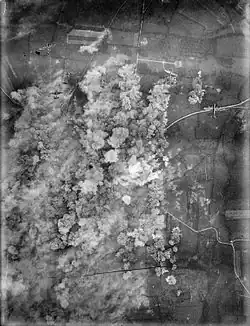 A photo taken from the air, showing plumes of smoke rise over a town