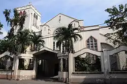 A tan church exterior with palm trees (Knox United Methodist Church)