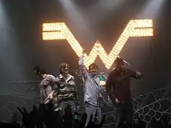 Four men together at the front of a stage