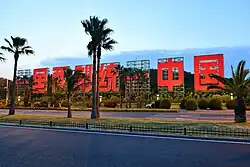 Large characters saying "One Country, Two Systems" and "Reunify China" on Xiamen Island's east coast, facing the nearby Kinmen Islands, Republic of China (Taiwan). Similar propaganda on Kinmen face Xiamen, reading "Three Principles of the People Unite China".