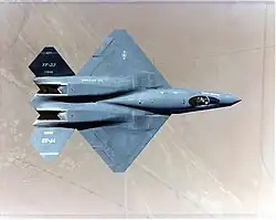 Top view of black jet aircraft, showing diamond wings, engine nozzles with exhaust trenches, and two-piece tail. The separation between the forward fuselage and engine nacelles is apparent.