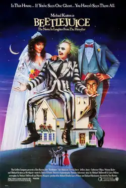 A woman in a wedding dress, a green haired white faced man in a striped suit, and on their right, a headless man whose head is being held by the green-haired man.