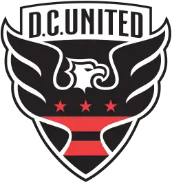 A shield with stylized black eagle facing right with three red stars and two red strips across its chest, and the words "D.C. UNITED" above.