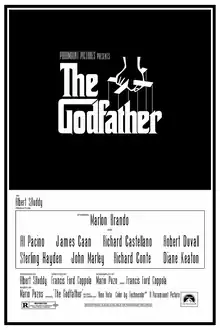 "The Godfather" written on a black background in stylized white lettering, above it, a hand holds puppet strings.