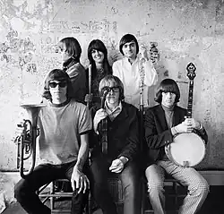 Group photo of Jefferson Airplane with hieroglyphics on the wall. Image taken by Herb Greene.