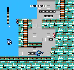 A square video game screenshot that depicts Mega Man firing a shot toward a vertical brick wall. Enemies surround the character and a score are visible at the top of the screenshot.