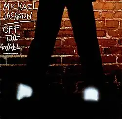 Against a brick wall, a man's bottom half of his legs, glowing socks, and black shoes are visible. It is cut from the original cover, and was also the original back cover.
