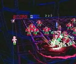 A horizontal rectangular video game screenshot that is a digital representation of a confined dark 3D space with a white and green character in the corner of the room. The character shoots a robot while surrounded by a large group red and green robots with a few humans behind them.