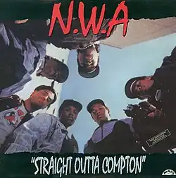 The members of N.W.A look down to the camera and Eazy-E points a gun to it