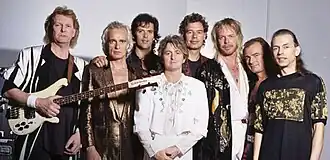 Promotional photograph of eight band members